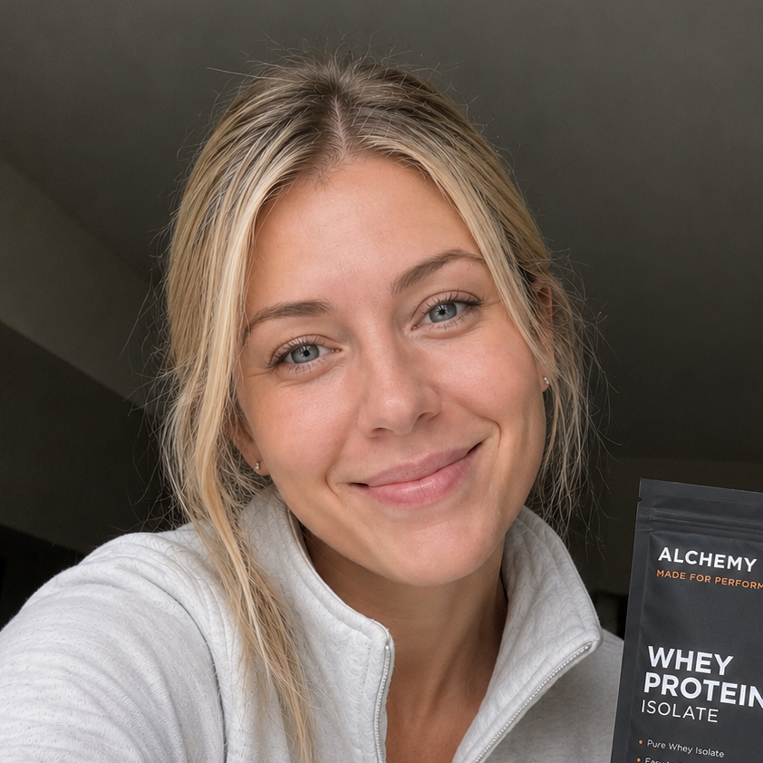 Woman holding a package of Alchemy whey protein isolate.